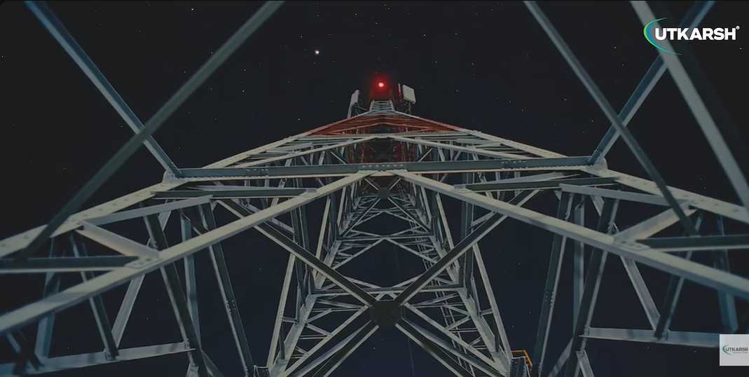 Telecommunication towers silhouetted against a colorful sunset